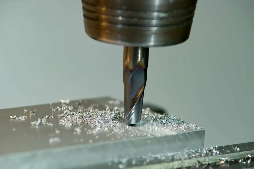 Una fresadora de roscas está mecanizando un bloque de aluminio con equipos CNC, produciendo roscas internas precisas que contrastan con los métodos tradicionales de roscado.
