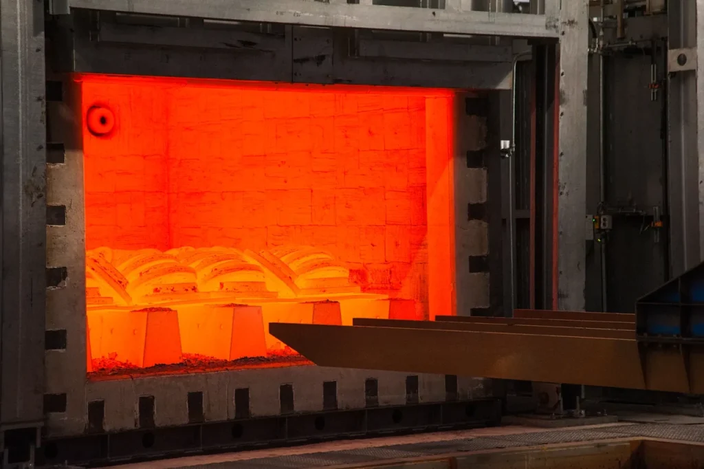 Forno industriale per il trattamento termico con interno rosso incandescente, che contiene componenti metallici per il riscaldamento controllato.