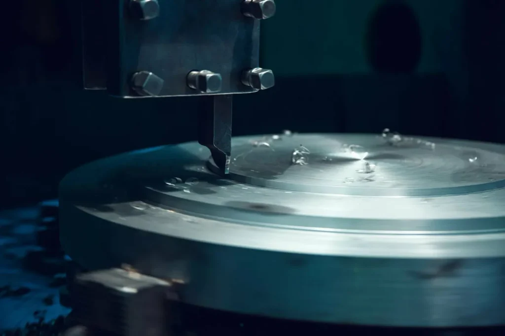 Soustružení velkého kovového disku na CNC soustruhu za účelem optimalizace využití materiálu a snížení výrobních nákladů.