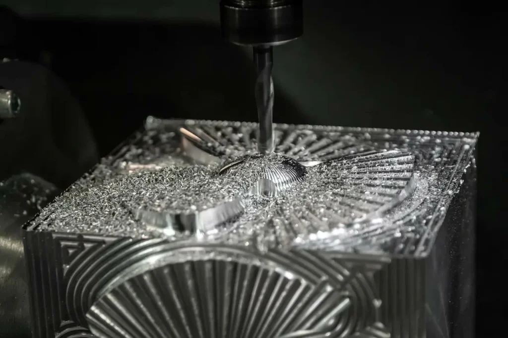 Detailní záběr na CNC stroj, který provádí tvrdé frézování hliníkového bloku a vytváří složité, vysoce přesné geometrie chladicích žeber.