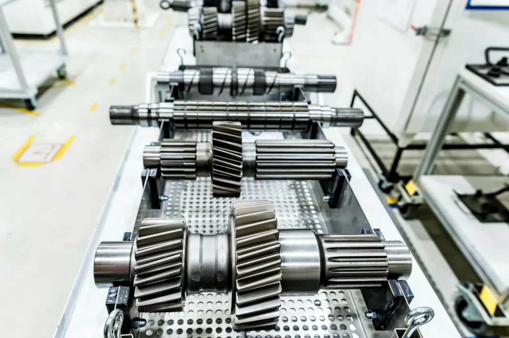 Finished gear assemblies on a production line highlight volume effects on CNC machining costs.