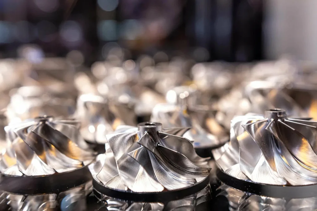 Primo piano di giranti di turbine metalliche di precisione, le cui superfici a specchio sono il risultato dell'elettrolucidatura per migliorare le prestazioni e la durata.