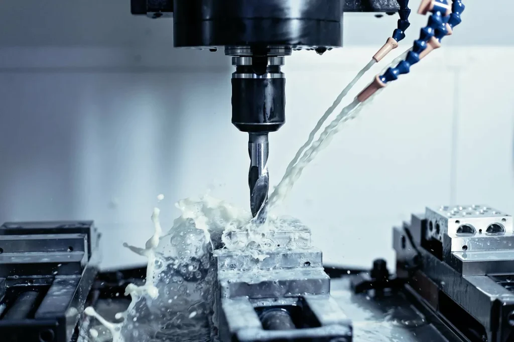 A CNC drill uses coolant while cutting metal, a consumable cost factor in machining operations.