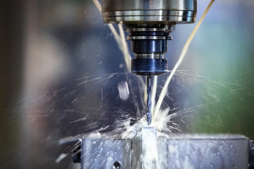 Frezarka CNC tnąca metal za pomocą chłodziwa, krok przed odprężeniem w celu ustabilizowania obrabianych elementów.