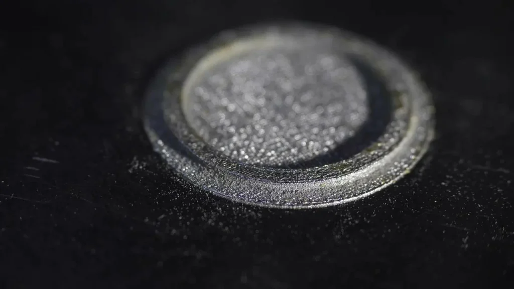 Gros plan d'une pièce métallique usinée, finie par programmation en code G et code M de la CNC.