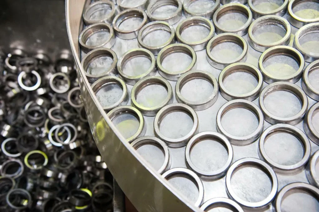 Uniform metal washers arranged in a vibratory finishing tub to achieve consistent deburring and surface polishing.