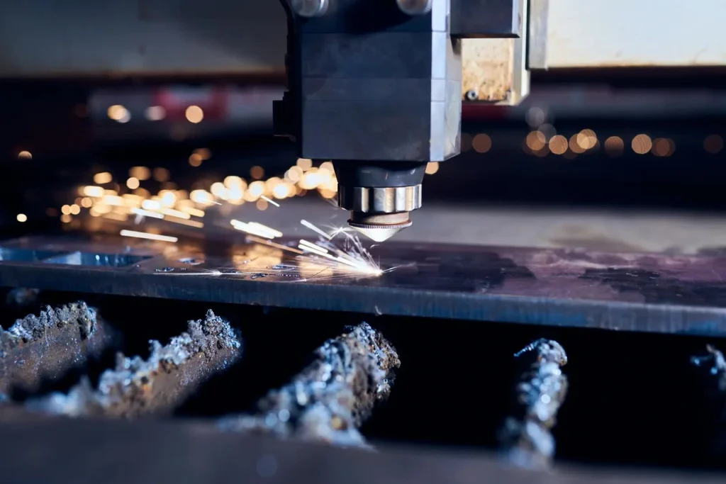 CNC laserový řezací stroj v provozu, který při zpracování plechu vytváří jiskry