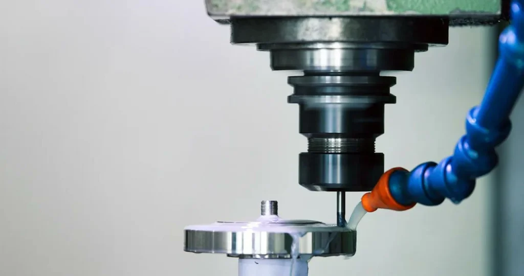 Una máquina CNC fresa una pieza metálica antes de aplicar un revestimiento de PTFE (teflón).