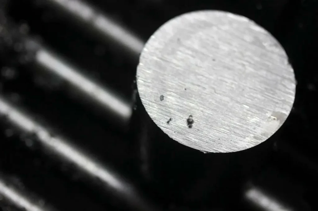 A machined aluminum rod shows a countersink or counterbore end finish.