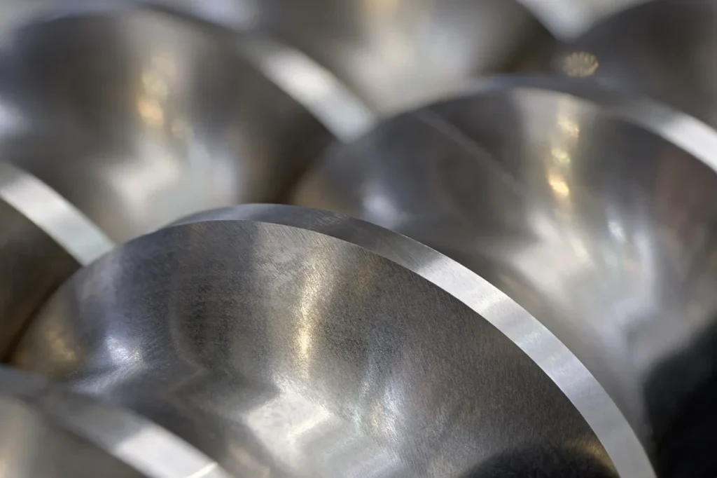 Bearbeitete konische Metallteile zur Veranschaulichung des Hauptunterschieds zwischen Rundlauf und Gesamtrundlauf in GD&T.