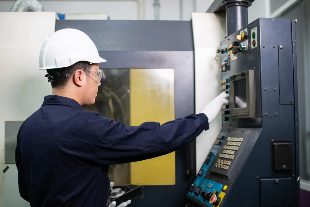 A skilled operator controls a CNC turning machine in a Chinese workshop.