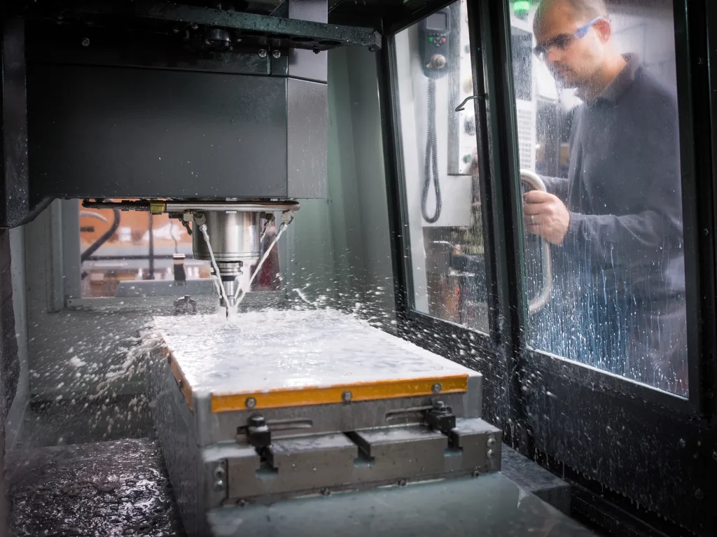 A CNC machine cuts metal, a process distinct from the shaping method of forging.