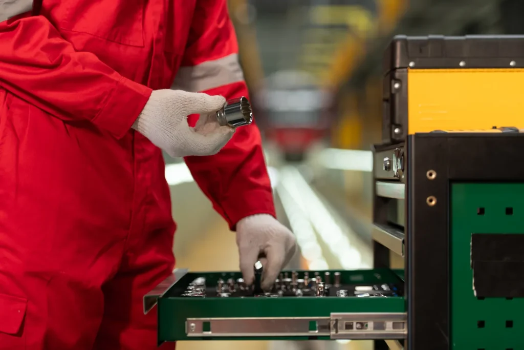 A worker prepares tools, essential for both the tooling in forging and CNC machining.