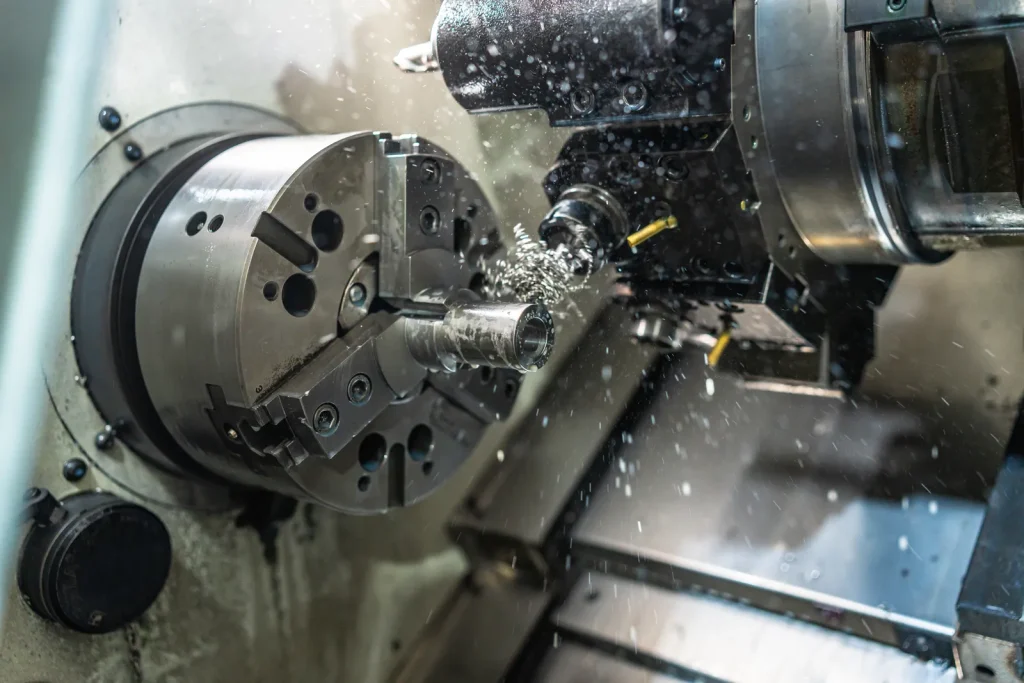 CNC-Drehmaschine beim Drehen eines Metallteils mit Kühlmittel, um die Unterschiede in der Bearbeitbarkeit von Titan und Wolfram zu verdeutlichen.