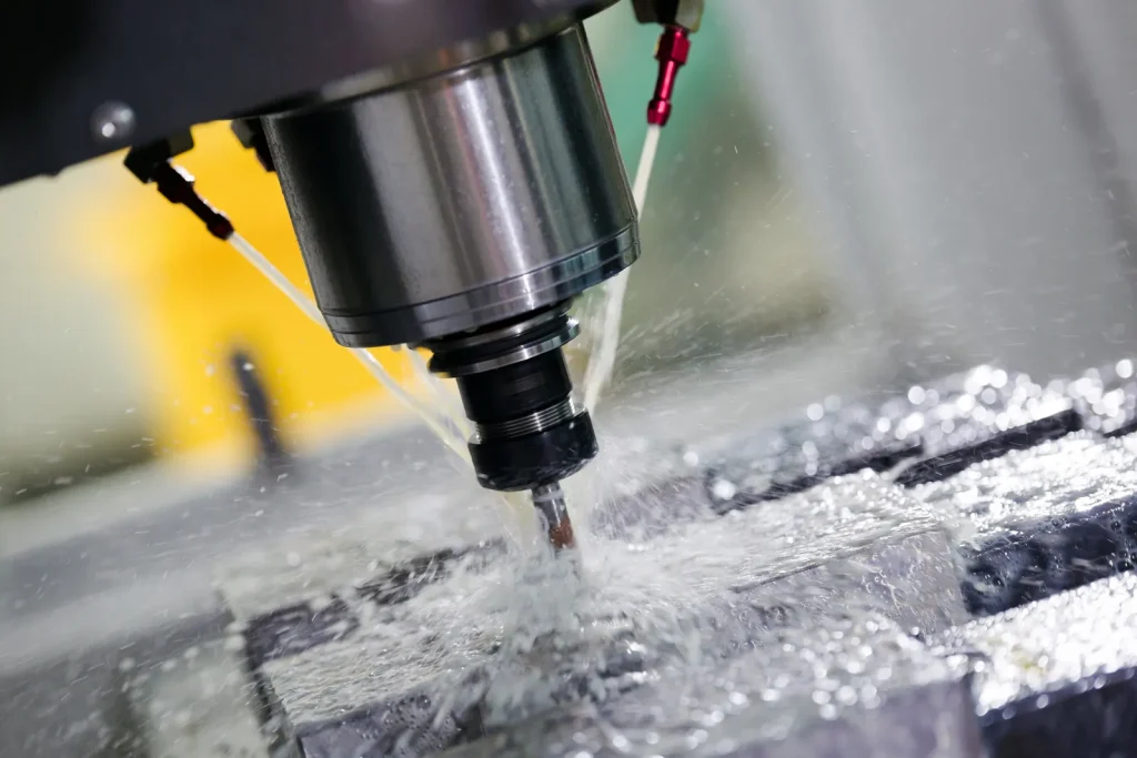 Close-up of 4-axis CNC cutting with coolant, demonstrating high-precision metalworking.