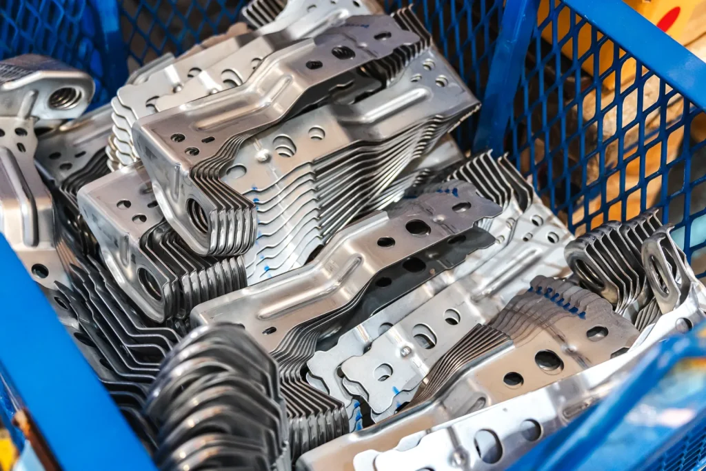 Finished stamped metal components are neatly arranged after production.