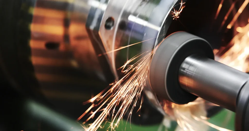Sparks fly as a CNC grinding machine processes a metal component.