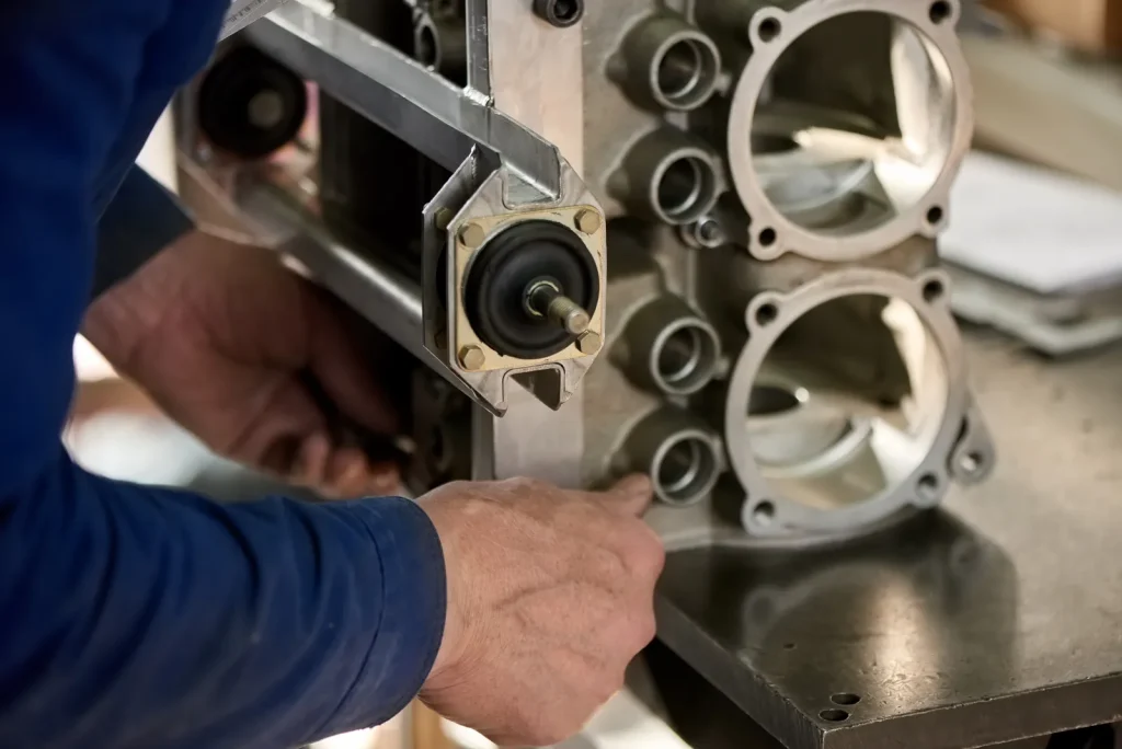 A worker assembles a component machined using precision CNC grinding services.
