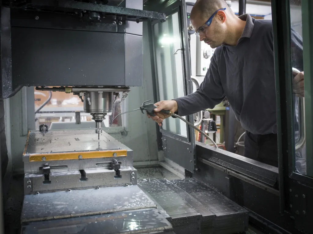 Un technicien effectue des opérations de maintenance sur une machine d'électroérosion à fil de précision.