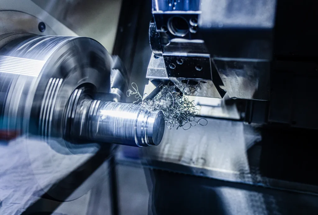A CNC lathe precisely machines a titanium workpiece, creating fine metal chips.