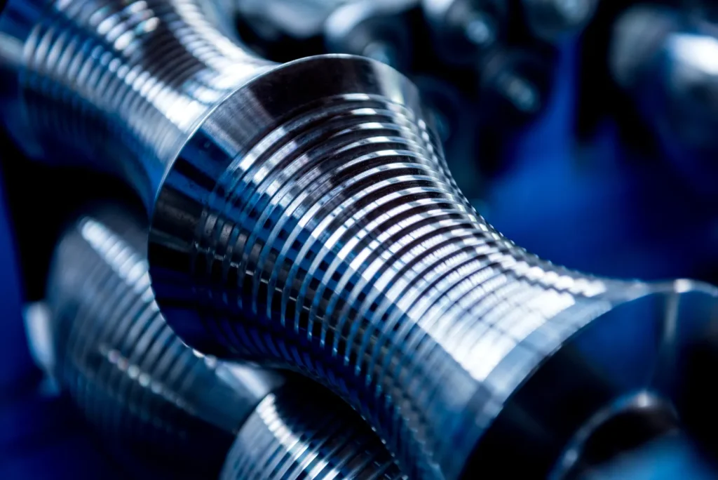 A close-up view shows a precision-machined titanium component from CNC turning.
