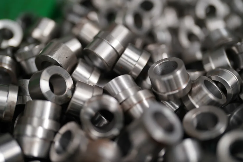 A pile of precision titanium components sits after CNC turning services.