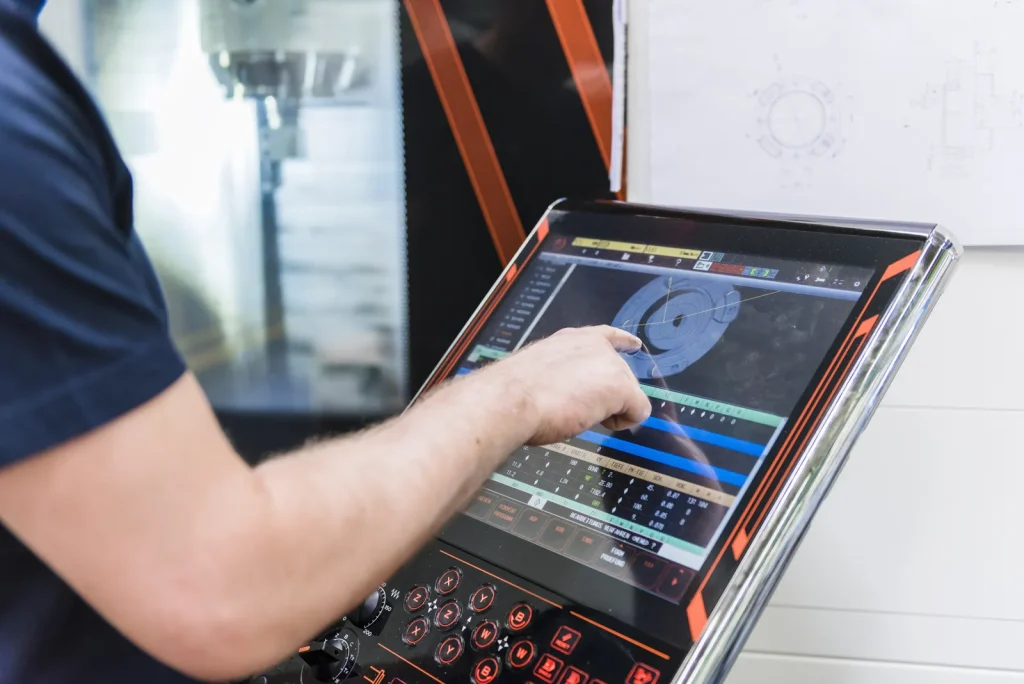 Inżynier zajmujący się programowaniem obróbki CNC w ramach hybrydowej produkcji medycznej z integracją procesów druku 3D.