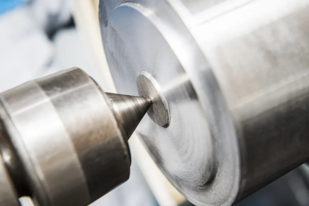 Close-up of a CNC lathe tool working on a metal workpiece to create a fine, smooth surface finish.